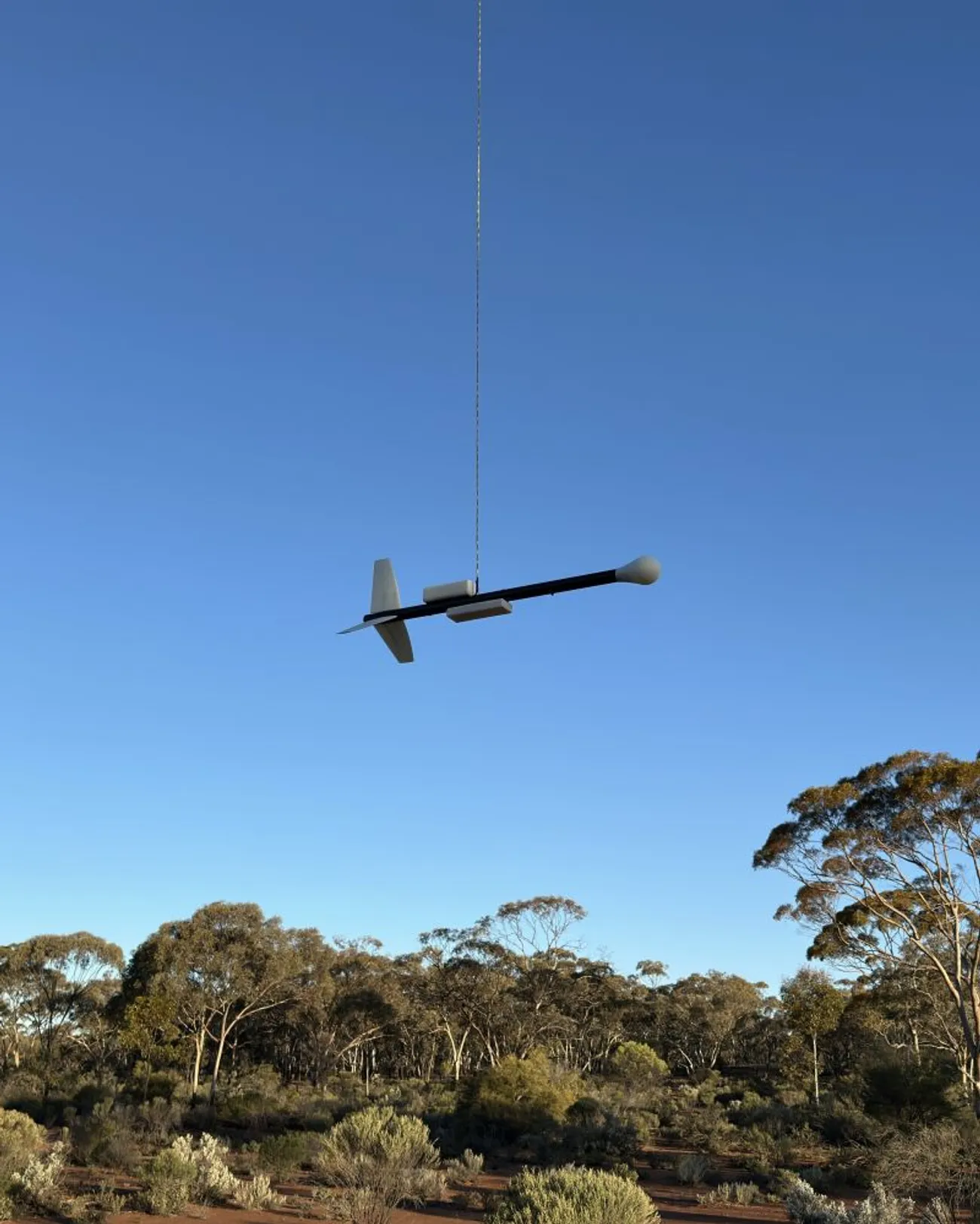 The QuSpin magnetometer bird in flight, towed below the drone on a long line